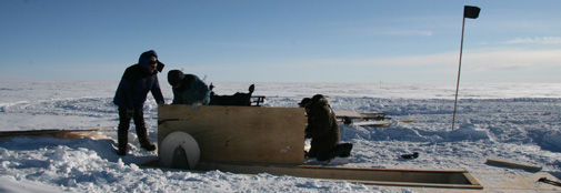 Sverrir, Oli and Hans Christian mount sections of 'the submarine' skylight on the drill trench roof.